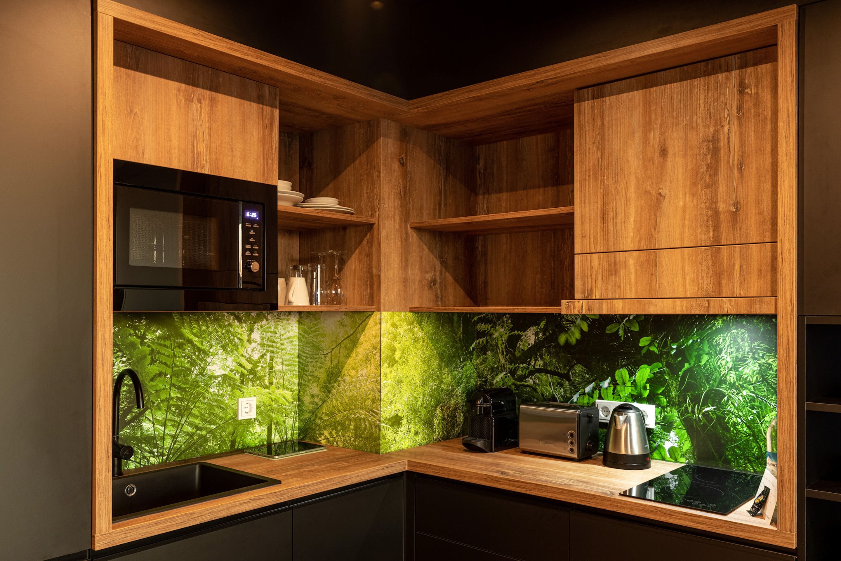 Una cocina moderna con armarios de madera, un microondas negro, un fregadero y una cafetera.