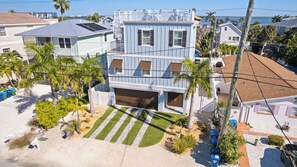 A multi-story house with a garage, solar panels, and a view of the ocean. - Floridaze- Luxury 6 bedroom private pool/spa and less than a 1-minute walk to th (Bradenton Beach)