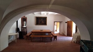 A dining area with a wooden table and benches, an arched ceiling, and a painting on the wall. - Casolare Fonte di Moro (Abruzzo)