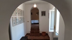 A hallway with a wooden bench, a staircase, and a door leading to a room. - Casolare Fonte di Moro (Abruzzo)