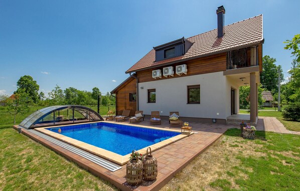 A two-story house with a swimming pool, outdoor seating, and a covered carport. - Pet friendly home in Gospic (Gospic)