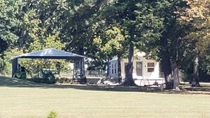 A lakeside park with a gazebo, a small building, and trees. - Water front cottage w/water access, firepit & great sunsets. (Vonore)