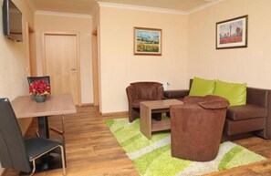 Quadruple Room | Living room | 32-inch flat-screen TV with satellite channels, TV - Hotel Austria (Saalbach-Hinterglemm)