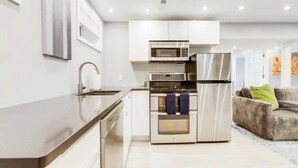 A modern kitchen with stainless steel appliances, a built-in oven, and a microwave. - Stylish Modern Suite in the Heart of Chevy Chase! (Washington)