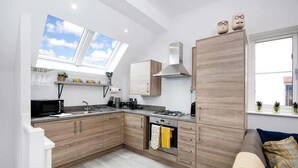 A modern kitchen with wooden cabinets, a gas stove, and a skylight. - Host & Stay | Captain's Retreat (Whitby)