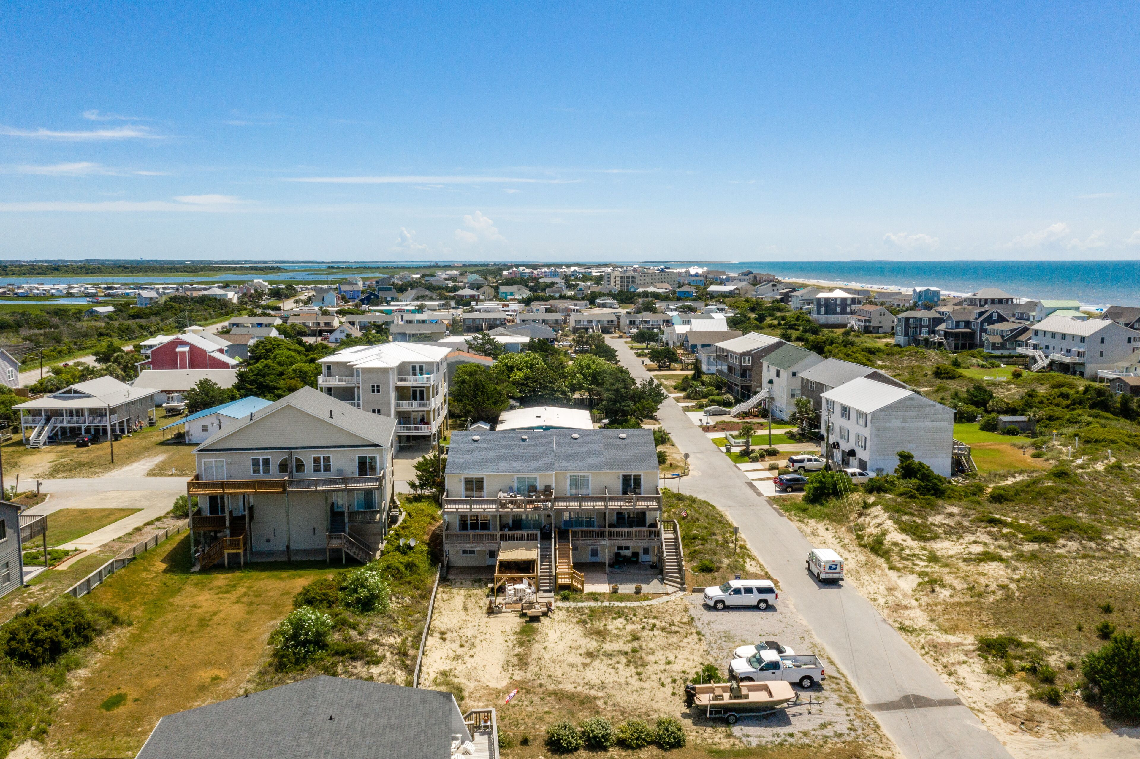 Zona residencial costera con casas, una playa y cielo despejado.