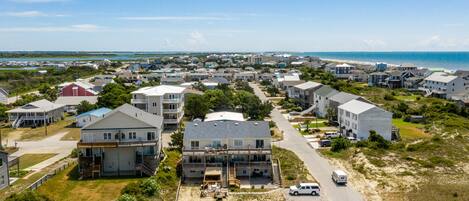 Zona residencial costera con casas, una playa y cielo despejado.