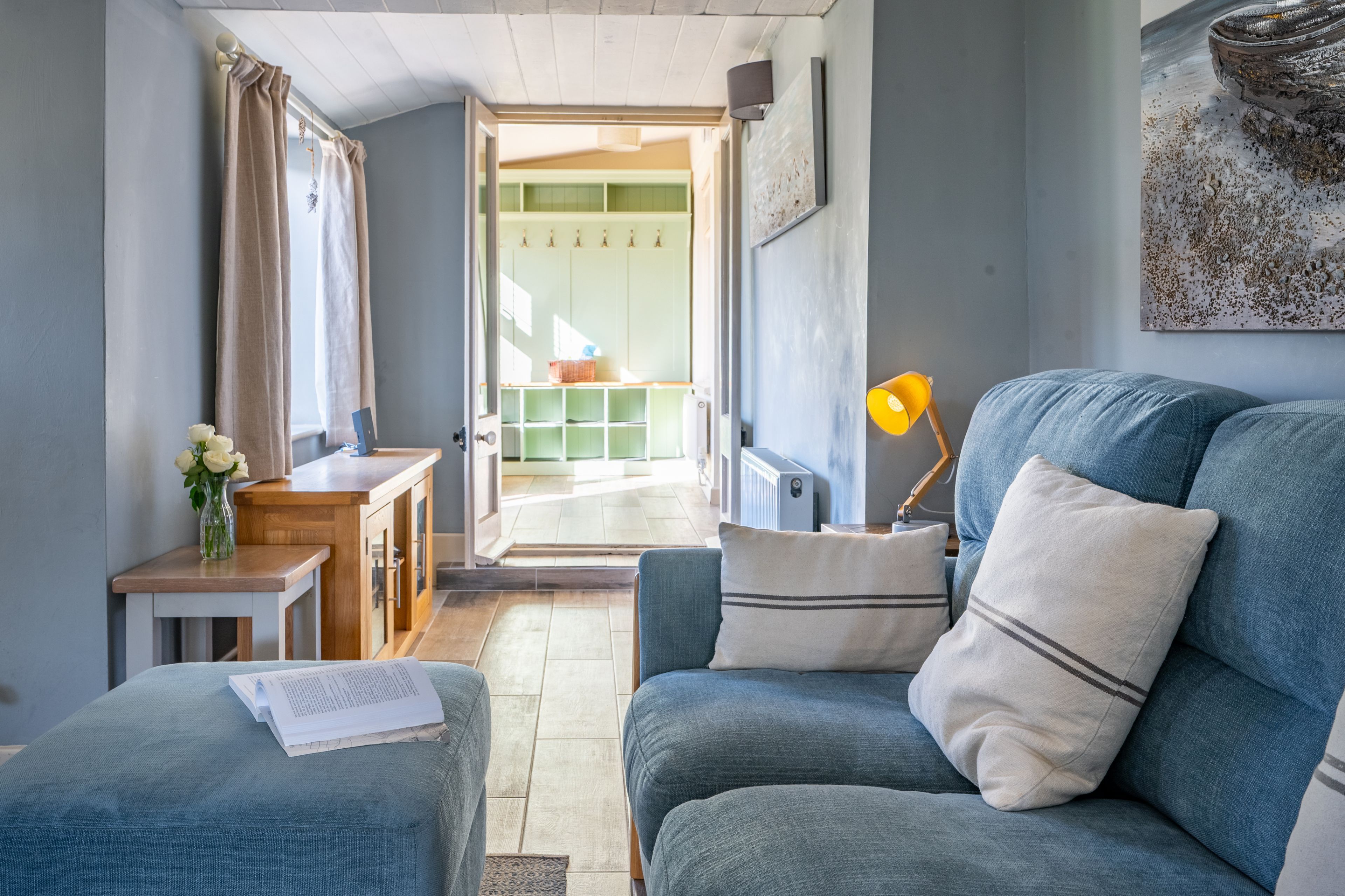 A cozy living room with a sofa, a small table, and a lamp.