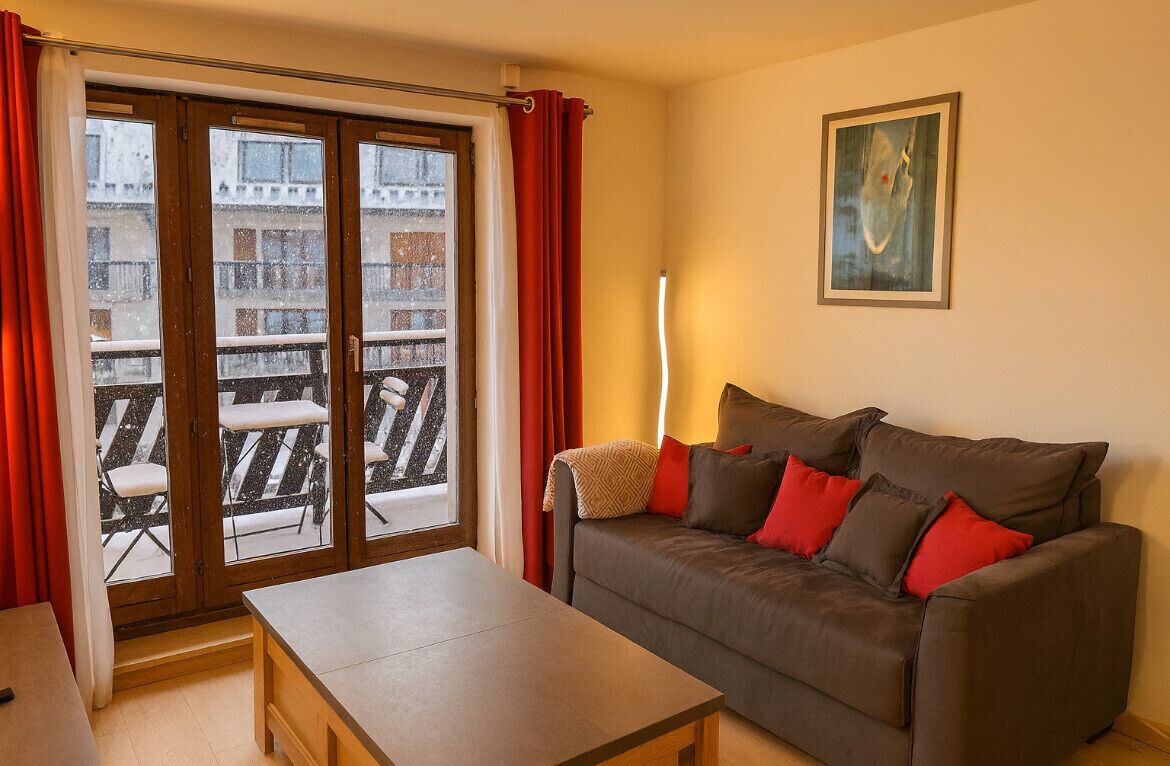 En stue med sofa, bord og balkon med stole.