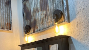 A bathroom vanity with a mirror, a light fixture above it, and a door with a handle.