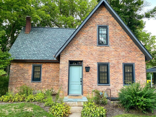 A brick house with a steep gable roof, a front door, and a small porch. - 3-Bedroom 🔸 Steps from Bucknell 🔸 Renovated (Lewisburg)