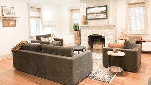 Un salon avec une cheminée, deux canapés, une table basse et un tapis.