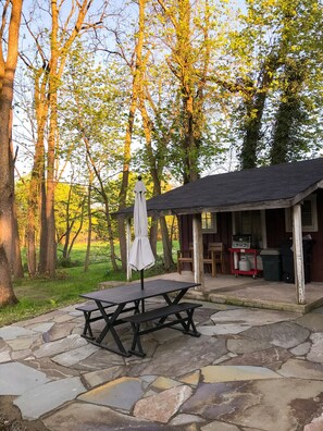A picnic table with an umbrella, a small shed, and a stone patio. - 3-Bedroom 🔸 Steps from Bucknell 🔸 Renovated (Lewisburg)
