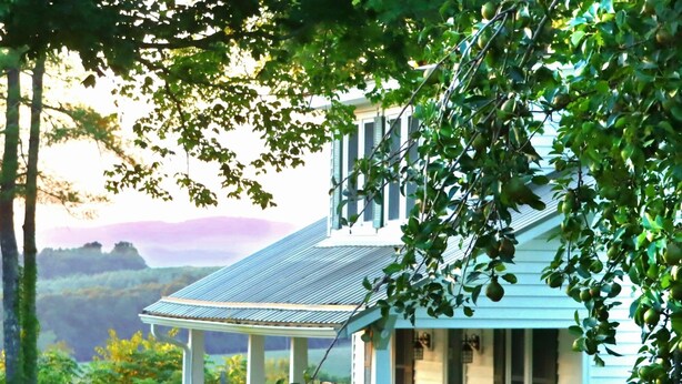 Una casa con porche, un espacio cubierto y vistas del paisaje.