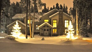 Suuri talo, jossa on huomiota herättävä savupiippu, ja jonka ympärillä on lumipeitteinen maa ja puita.