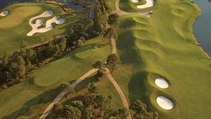 En golfbana med sandbunkrar, vattenhinder och en välskött fairway.