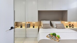 Une chambre à coucher moderne, avec un lit, des tables de chevet et une armoire.