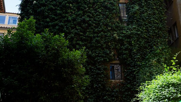 A tall building with a brick facade and multiple windows. - Torre dei Sapiti Apartment with private courtyard (Firenze)