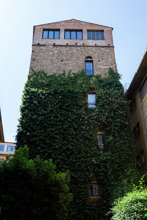 A tall building with a brick facade and multiple windows.