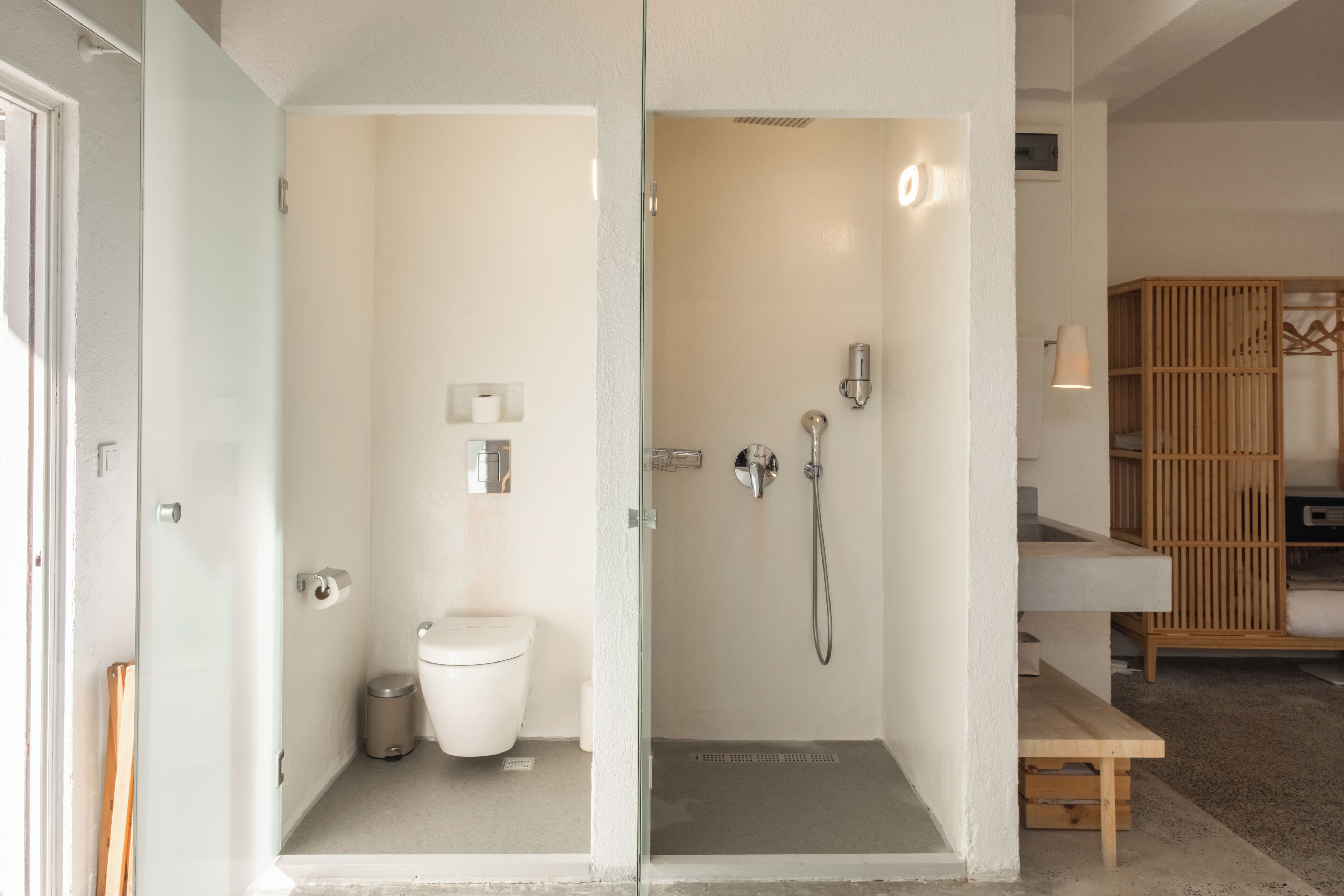 A modern bathroom with a glass shower enclosure, a toilet, and a sink.