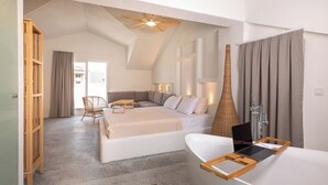 Un dormitorio moderno con una cama grande, una silla de madera, un escritorio y un baño con bañera y ducha.