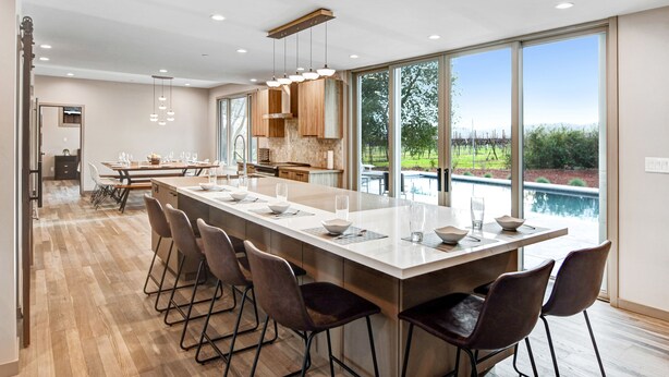 A modern kitchen with a large island, bar stools, and a view of a swimming pool. - Chardonnay Estate - 6 Suites in the heart of wine region 2 ml from Sonoma Square (Sonoma)