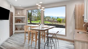 A modern kitchen with a large window, wooden furniture, and a built-in wine rack. - Chardonnay Estate - 6 Suites in the heart of wine region 2 ml from Sonoma Square (Sonoma)