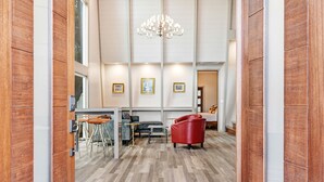 A modern interior with a wooden floor, a chandelier, and a seating area with a red chair and a grey sofa. - Chardonnay Estate - 6 Suites in the heart of wine region 2 ml from Sonoma Square (Sonoma)