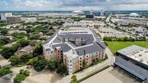 Un grand bâtiment à plusieurs étages, doté d’une cour centrale entourée de constructions plus petites.