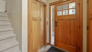 Eine Holztür mit Glasfenster, ein Teppich und ein helfarbener Wand.