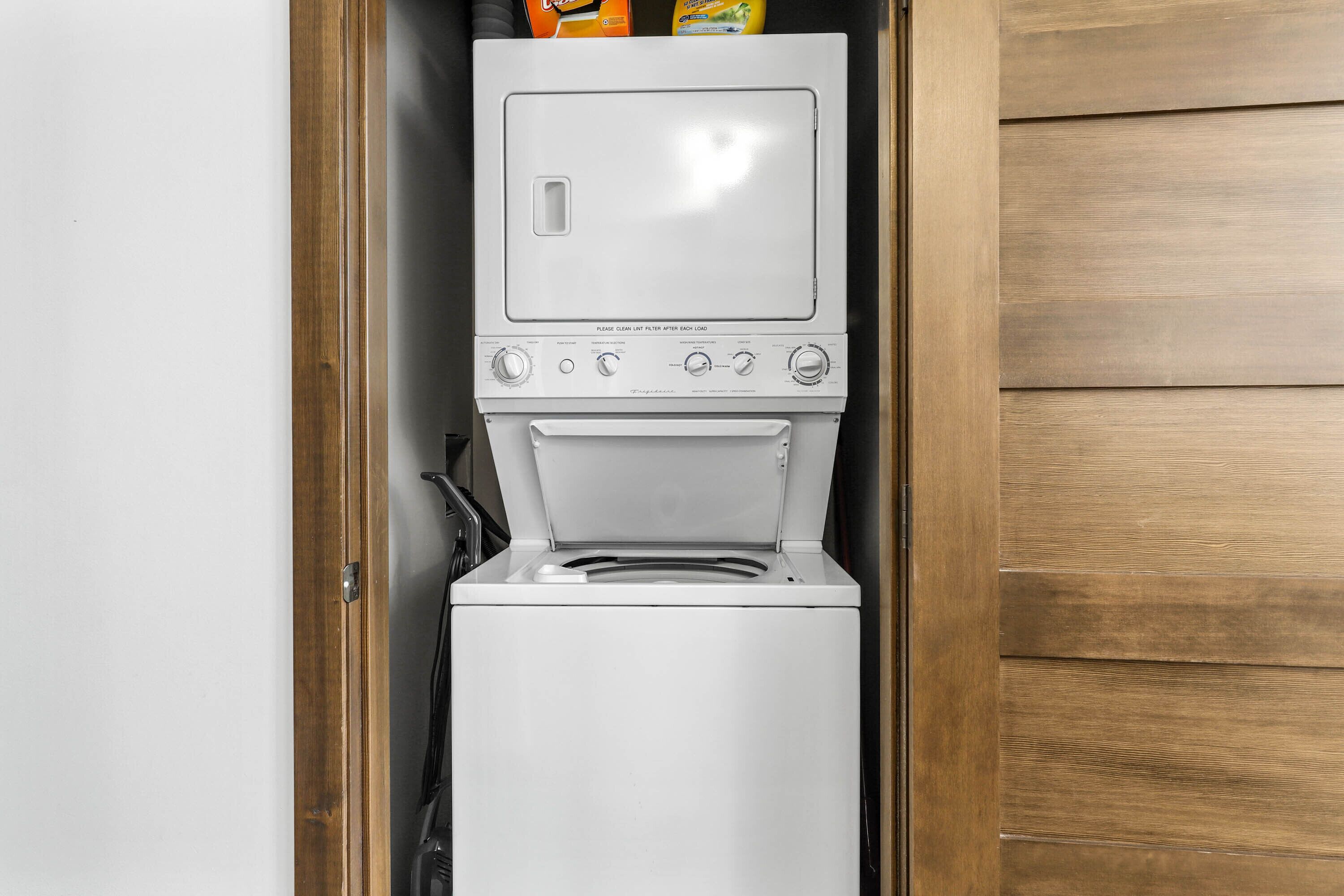 A compact washer and dryer unit with a control panel and a top-loading door.