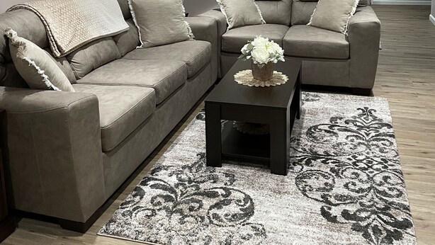 A living room with a grey sofa set, a coffee table with a vase, and a patterned rug. - Luxurious, private, contemporary 1BR apartment in Ithaca NY!  (Ithaca)