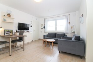 Relax in this spacious living area with a sofa, coffee table, and flat-screen TV. Enjoy meals at the dining table and cook in the fully equipped kitchen.