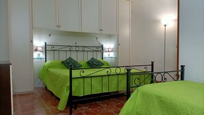 Un dormitorio con cama, mesita de noche, lámpara y armario.