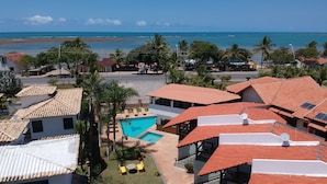 Un quartier résidentiel avec des maisons, une piscine et une vue sur la plage.