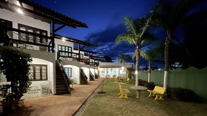 A two-story house with a patio area, outdoor seating, and a well-lit entrance. - Mutá Praia Hotel (Porto Seguro)