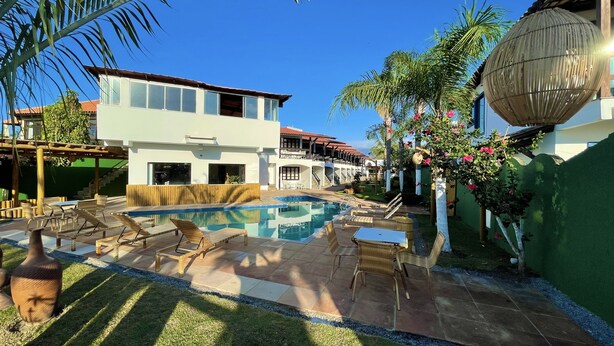 A modern resort with a swimming pool, lounge chairs, and a well-maintained garden. - Mutá Praia Hotel (Porto Seguro)