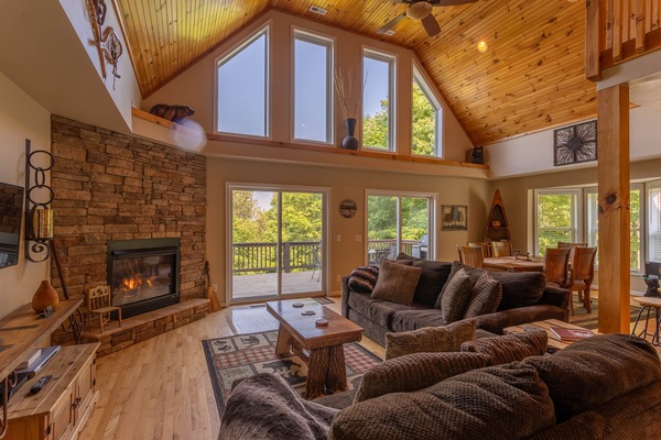 Gather around a glowing stone fireplace under soaring wood-planked ceilings, with the Blue Ridge treetops just beyond the glass.