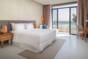 A hotel room with a large bed, a desk, a chair, and a view of the ocean. - Wyndham Garden Cam Ranh Resort (Cam Ranh)