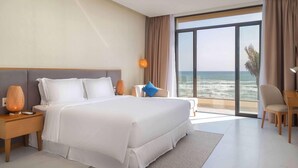 A modern hotel room with a large bed, a nightstand, a desk, and a view of the ocean. - Wyndham Garden Cam Ranh Resort (Cam Ranh)