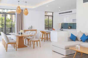 A modern living space with a dining area, kitchen, and seating area.
