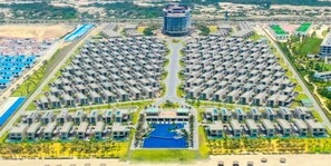 A large, modern resort with numerous rectangular buildings arranged in a symmetrical pattern around a central pool. - Wyndham Garden Cam Ranh Resort (Cam Ranh)
