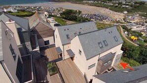 Zona residencial costera con casas modernas, una playa y un estacionamiento.