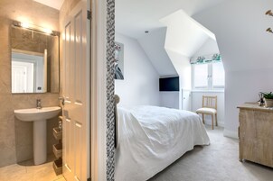 Un dormitorio con cama, cómoda, silla y ventana.