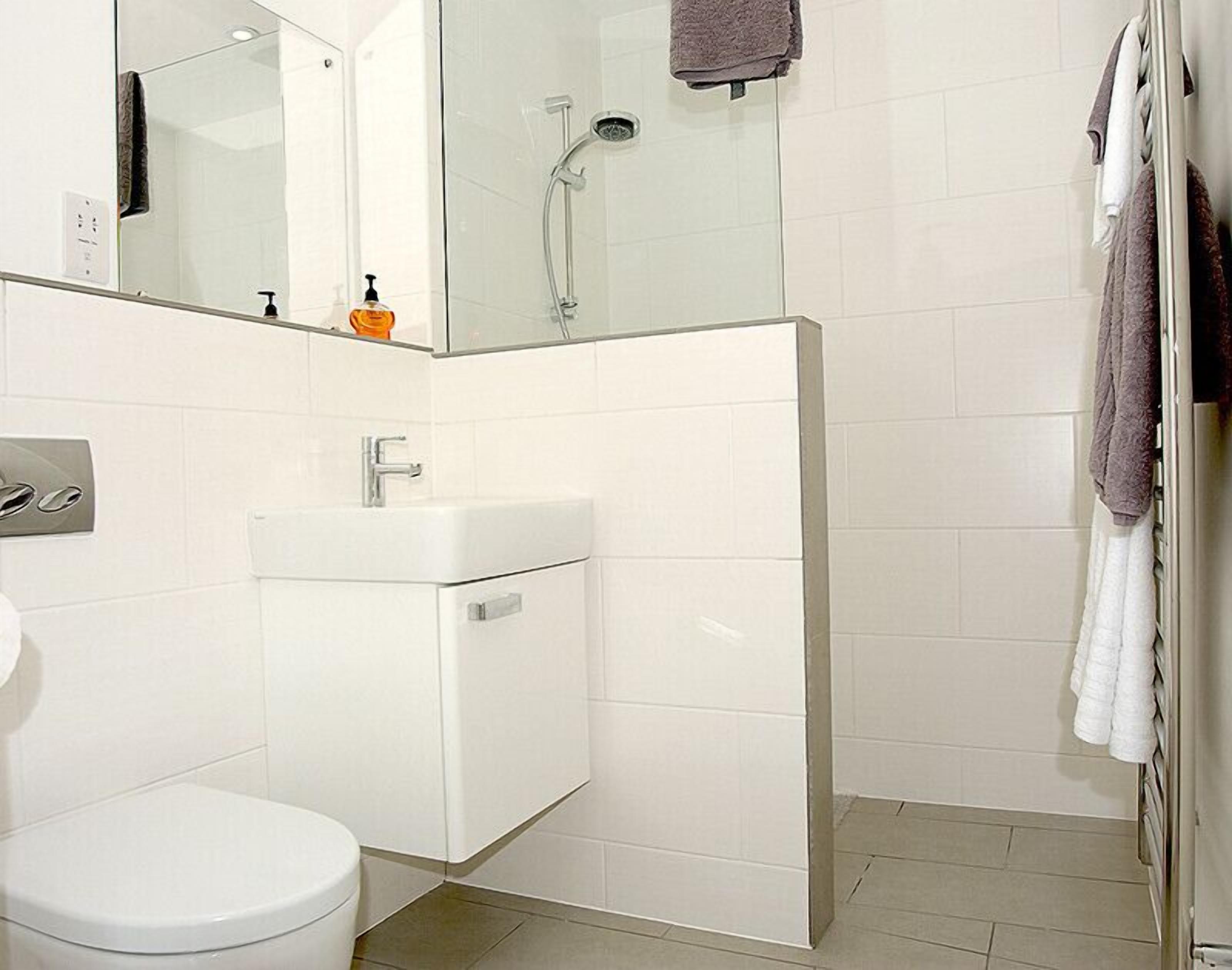 A modern bathroom with a toilet, sink, and shower.