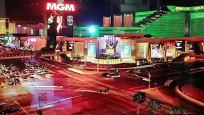 Ett väl upplyst kasino med en stor skylt med texten ”MGM”, flera skärmar och en livlig korsning.