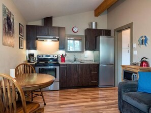 Enjoy cooking in this well-equipped kitchen with a stove, oven, and refrigerator, and dine at the adjacent table.