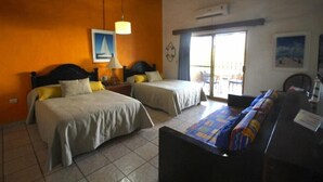 Une chambre d’hôtel avec deux lits, un bureau et une vue sur l’extérieur.