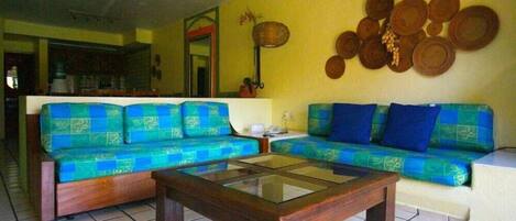 Una sala de estar con dos sofás, una mesa de centro y una pared decorada con objetos circulares.