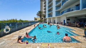 A swimming pool area with multiple levels of balconies, a lifeguard stand, and a clear sky. - Beautiful 17th Floor Views! Free Activities + Summer Deals!! (Panama City Beach)